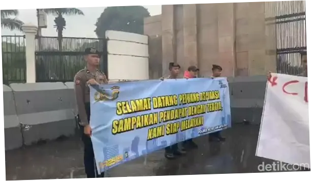 Momen Polisi Kawal Demonstrasi di Gedung DPR di Tengah Hujan